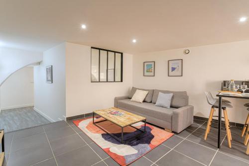 un salon avec un canapé et une table dans l'établissement Le Siméon - T2 plein pied, cosy, au cœur de la zone piétonne, à Vienne