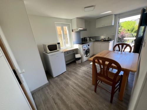 Il comprend une cuisine avec une table, deux chaises et une table. dans l'établissement Appartement fonctionnel, à Mandelieu-la-Napoule