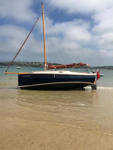 a sailboat sitting on the shore of a beach at Trewethen Cottage Barn 2 near Port Isaac in Port Isaac