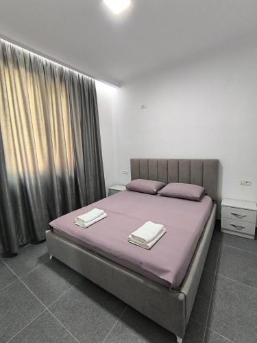 a bedroom with a bed with two towels on it at KAFUL APARTMENTS in Qeparo