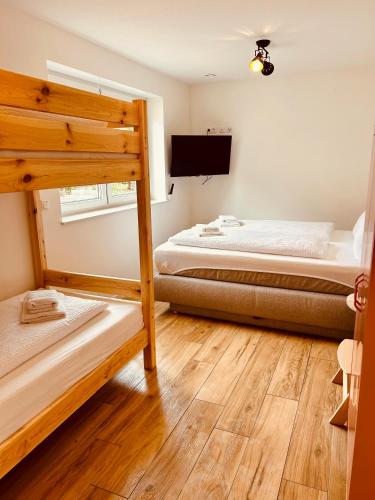 a bedroom with two bunk beds and a flat screen tv at Swiss City Apartments Rust in Rust