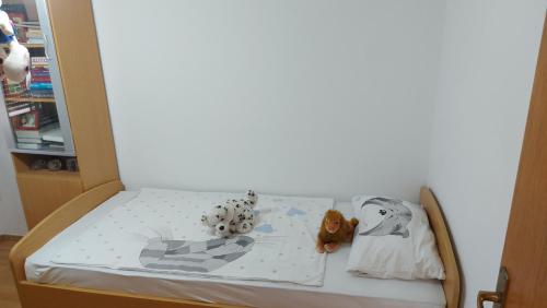 a bed with stuffed animals on it in a room at Apartman MN in Čapljina