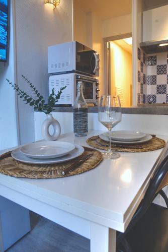 - une table avec deux assiettes et un verre de vin dans l'établissement Nouveau charmant Studio à 5 Minutes de la mer, à Nice