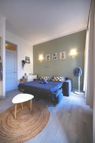 - une chambre avec un lit, une table et un tapis dans l'établissement Nouveau charmant Studio à 5 Minutes de la mer, à Nice