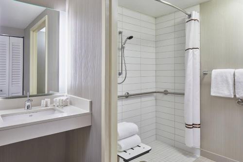 a white bathroom with a sink and a shower at Courtyard Portland Downtown / Convention Center in Portland