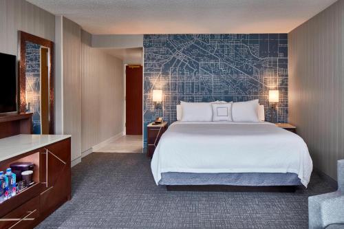 a hotel room with a large bed and a tv at Courtyard Portland Downtown / Convention Center in Portland