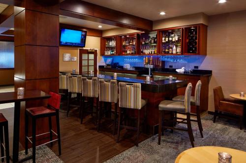 a bar in a restaurant with chairs and tables at Courtyard by Marriott Bloomington Mall of America in Bloomington