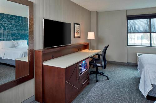 a hotel room with a desk with a tv and a bed at Courtyard Portland Downtown / Convention Center in Portland