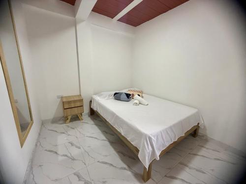 um quarto branco com uma cama com um bicho de pelúcia em Apartamento Piso 1 Casa 6 Hotel Atlantis em Líbano