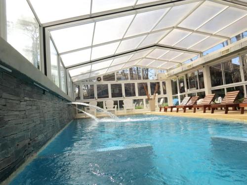 a swimming pool with a water fountain in a building at La Posta de Cariló in Carilo
