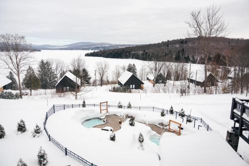 a snow covered village with a playground in the snow at Station Touristique Duchesnay - Sepaq in Sainte-Catherine