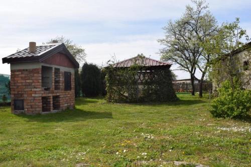 an old brick building in a grassy field at Apartament Domowe Zacisze 2 in Kierzkowo