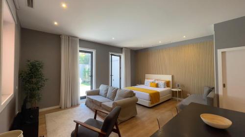 a bedroom with a bed and a couch and a table at MyTrip Porto in Matosinhos