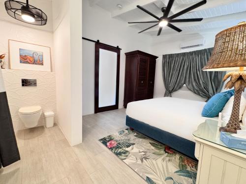 a bedroom with a bed and a ceiling fan at Treasure By The Sea Bonaire in Kralendijk