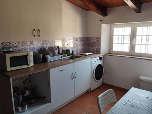 a kitchen with a washing machine and a microwave at Casa María in Estación de Cártama