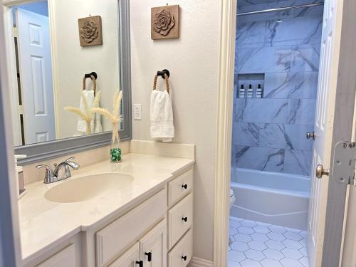 a white bathroom with a sink and a shower at Serene Lakefront Retreat with Scenic Views in Hickory Creek