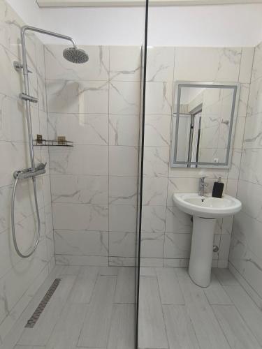 a bathroom with a shower and a sink at KAFUL APARTMENTS in Qeparo