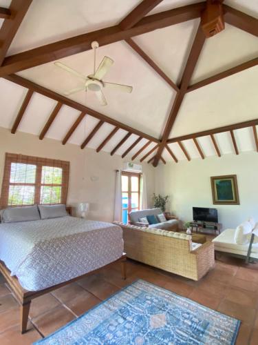 una camera con letto, divano e soffitto di Ocean Loft - Surf & Serenity Retreat a Los Destiladeros