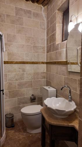 a bathroom with a toilet and a sink at Konak Bezirhane Cave Otel in Urgup