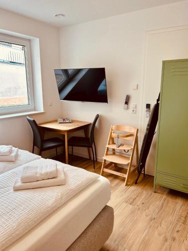 a bedroom with a bed and a table and a television at Swiss City Apartments Rust in Rust