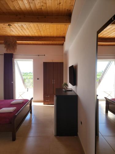 a living room with a bed and a television at Lahuta e Vjeter Agroturizem in Laç
