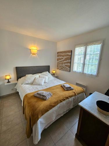 une chambre avec un grand lit avec deux serviettes dessus dans l'établissement Bel appartement Erbalunga- A deux pas de la plage, à Brando