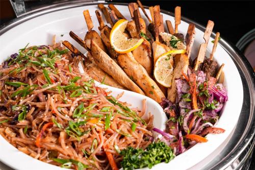 a plate of food with noodles and other foods at Park Inn by Radisson Dubai Motor City in Dubai