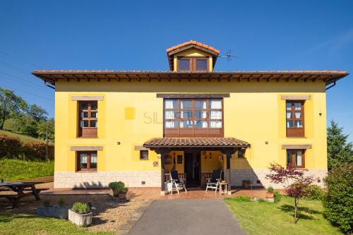 a yellow house with a table and chairs in front at El Balcón Del Profesor By Silastur in Cereceda