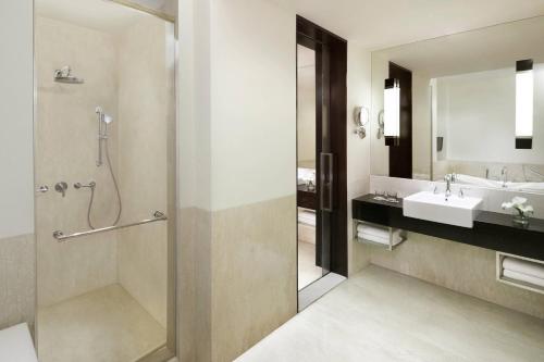 a bathroom with a shower and a sink at Courtyard by Marriott Bandung Dago in Bandung