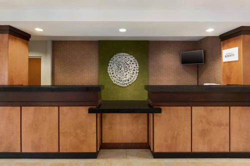 a lobby with wooden cabinets and a tv on a wall at Fairfield Inn & Suites Jacksonville West/Chaffee Point in Jacksonville
