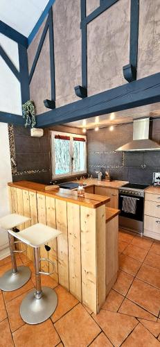 une grande cuisine avec des comptoirs et des tables en bois dans l'établissement Maison calme en bord de rivière, à Guiche