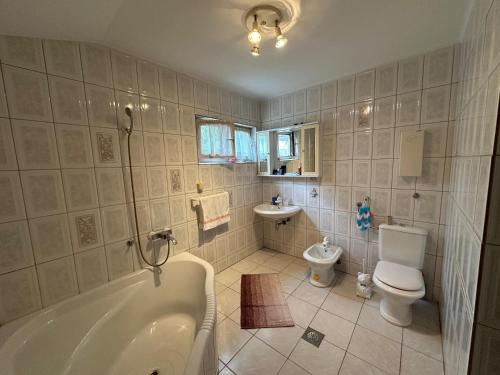 ein Badezimmer mit Badewanne, Toilette und Waschbecken in der Unterkunft City Center Home in Sarajevo