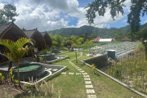 a garden with a swimming pool and some buildings at Nirwana Kintamani in Kubupenlokan