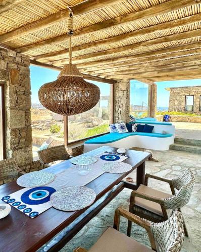 a dining room with a wooden table and chairs at Villa Ruffi Mykonos in Mikonos