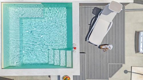 a person standing at the front of a swimming pool at Aquarius Deluxe Apartments in Santa Teresa Gallura