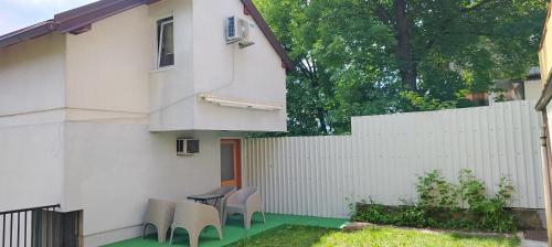 a patio with chairs and a white fence at Sarajevo Garden House in Sarajevo
