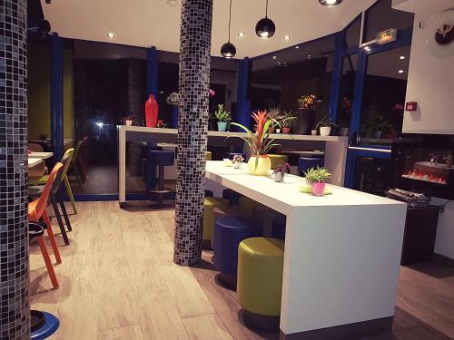 a restaurant with a white counter with plants on it at Ibis budget Lille Ronchin - Stade Pierre Mauroy in Ronchin