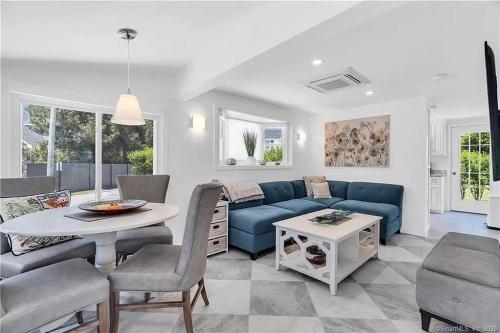 un soggiorno con un divano blu e un tavolo di Charming New Beach Cottage a Westbrook