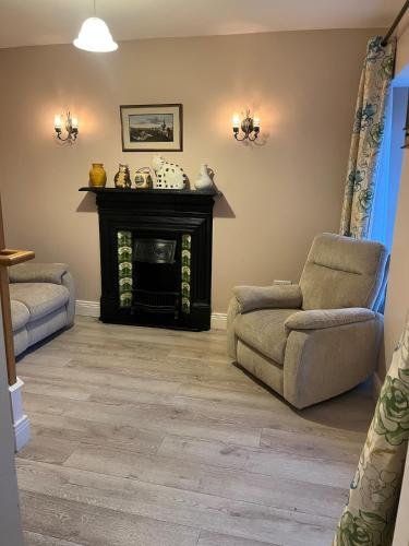 a living room with a fireplace and a chair at Self catering apartment Silvermines in Nenagh