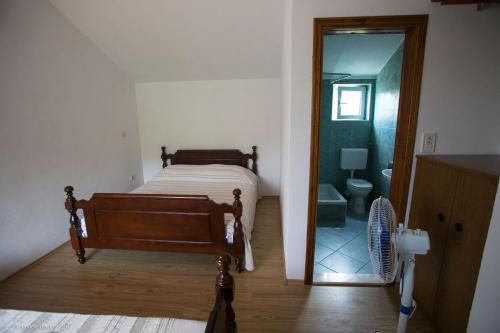 a bedroom with a bed and a bathroom with a mirror at Agrotourism Matusko in Neum