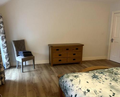 a bedroom with a bed and a dresser and a chair at Self catering apartment Silvermines in Nenagh
