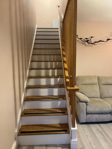 a staircase in a living room with a couch at Self catering apartment Silvermines in Nenagh