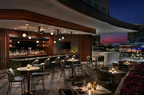 a restaurant with a bar with tables and chairs at The Ritz-Carlton Residences, Waikiki Beach Hotel in Honolulu