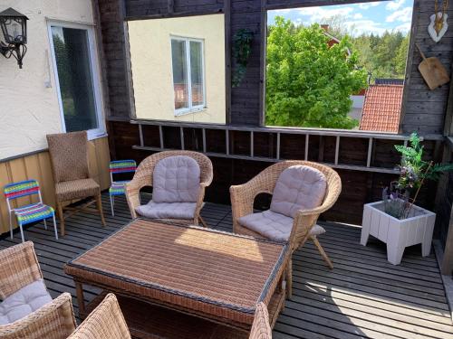 a patio with wicker chairs and a table on a deck at Vandrarhem Solgården in Blackstad