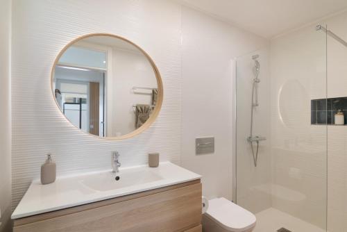 een badkamer met een wastafel en een spiegel en een toilet bij Chez Oti Puerto Rico in Puerto Rico de Gran Canaria