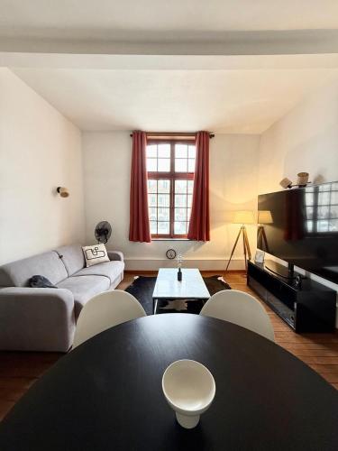 un salon avec une table et un canapé dans l'établissement Beffroi's Cosiest Place, à Arras