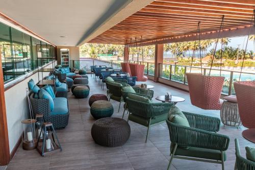 a restaurant with colorful chairs and tables and windows at Japaratinga Lounge Resort - All Inclusive in Japaratinga