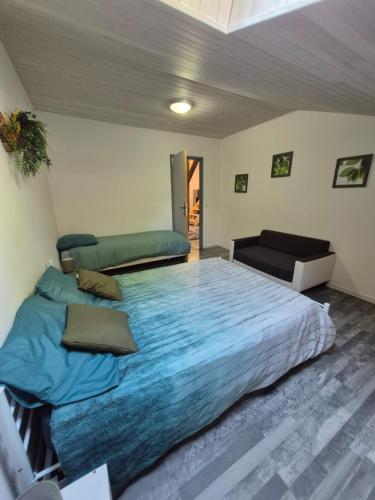 a bedroom with a large bed with blue sheets at Domaine de Beaudefour in Anthé