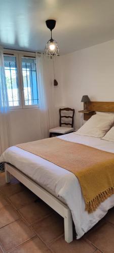 une chambre avec un grand lit et une chaise dans l'établissement séjour en amoureux, Cocktail de bienvenue sur notre terrasse Provençale, à Hyères