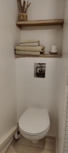 La salle de bains est pourvue de toilettes blanches et de serviettes. dans l'établissement séjour en amoureux, Cocktail de bienvenue sur notre terrasse Provençale, à Hyères